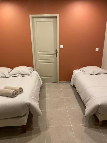 two beds sitting next to each other in a room at Hôtel La Lavande in Carpentras