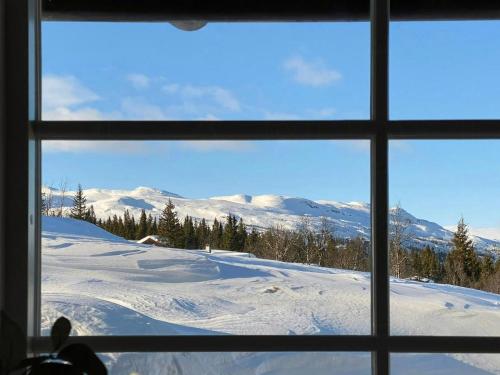 ein Fenster mit Blick auf die schneebedeckten Berge in der Unterkunft Cabin With Panoramic View In Synnfjell in Nord Torpa