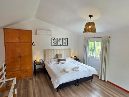 Un dormitorio con una cama y una cómoda y una ventana. en La Margarita Lofts, en Mina Clavero