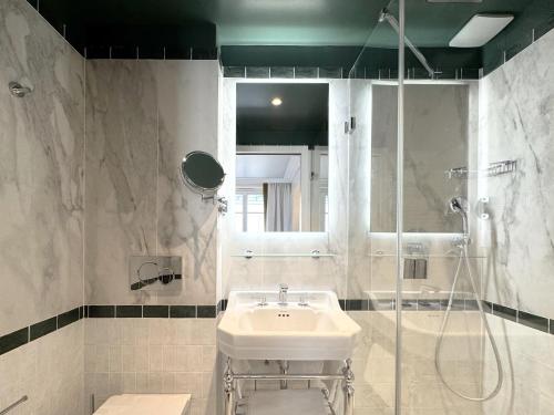 a bathroom with a sink and a shower at Hôtel Almarine Eiffel by Malone in Paris