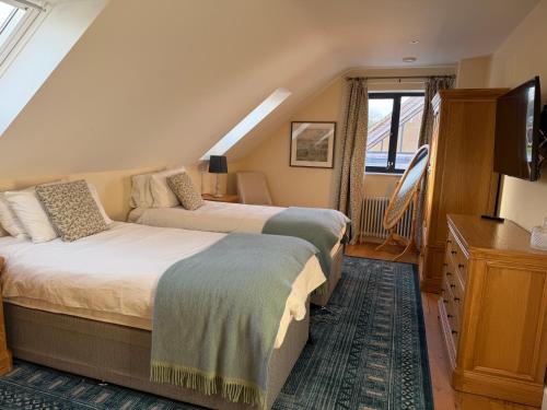 een slaapkamer met 2 bedden en een tv op zolder bij Meadow View House at Pudleston Court in Docklow