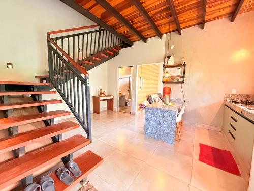 a kitchen with a staircase and a living room at Chalé Baru - Ar-cond - Varanda Pôr do Sol - Cavalcante Goiás in Cavalcante