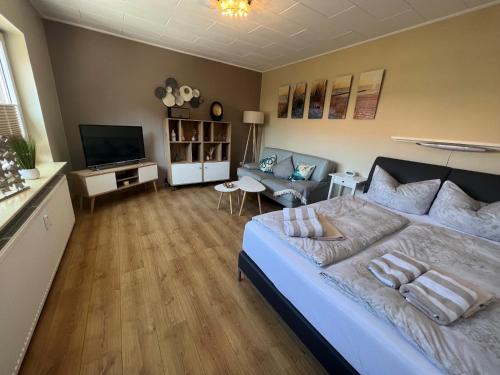 a bedroom with a large bed and a living room at Hooge Hörn Bantje Wohnung 3 in Borkum