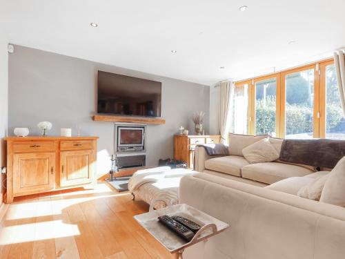 uma sala de estar com um sofá e uma TV em High View House em Kemeys Inferior