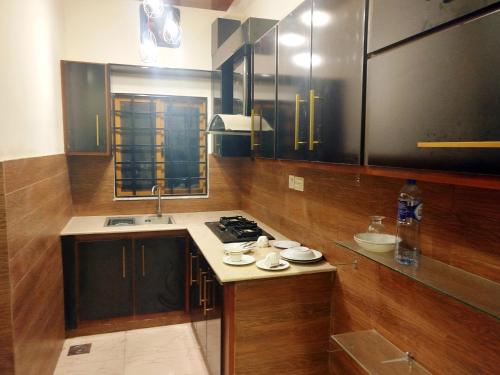 a kitchen with a sink and a stove in it at The Warmer House Islamabad Airport in Islamabad