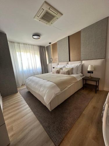 a bedroom with a large bed with white sheets and pillows at Centar Residence in Slavonski Brod