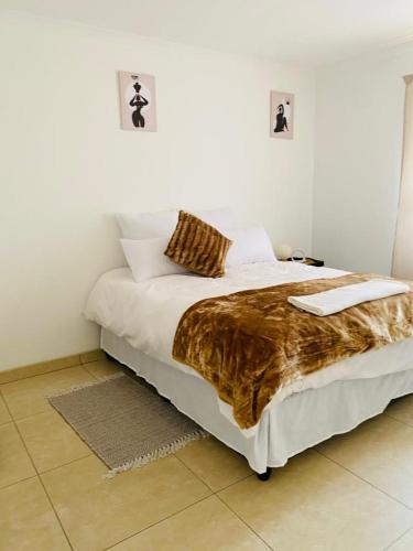 a bedroom with a bed with a faux fur blanket at Tasha Coastal Accommodation in Walvis Bay