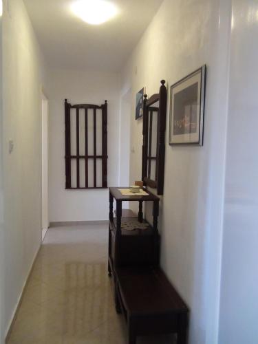 a hallway with a table and a mirror on a wall at Apartment Nada in Ston