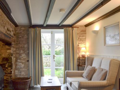 ein Wohnzimmer mit einer Couch und einem Fenster in der Unterkunft Mulberry Cottage - 27905 in Langton Matravers