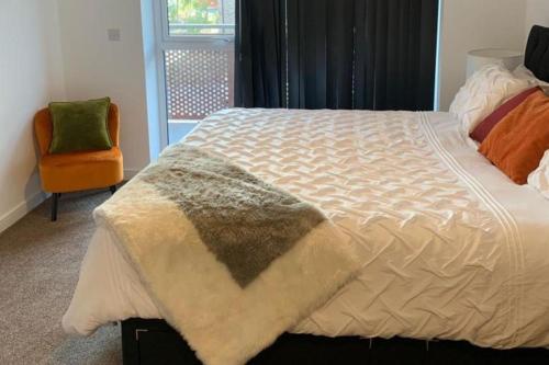Un dormitorio con una cama grande y una silla. en Flat-Sleeps 4 & Direct links to Central London, en West Thurrock