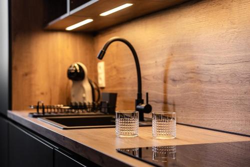 Twee glazen staan op een aanrecht in de keuken, naast een gootsteen. bij Beprime San Felipe Neri in Málaga