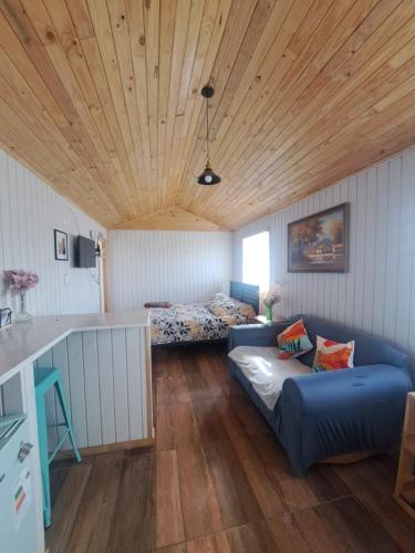 a living room with a couch and a bed at Tiny House Aeropuerto el Tepual in Puerto Montt