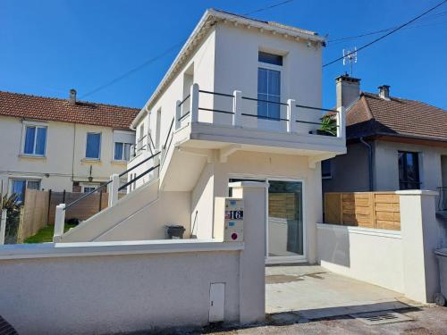 a white house with a staircase in front of it at L'Espadon in Luc-sur-Mer