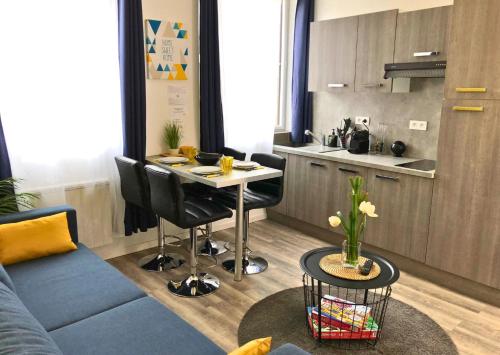 a living room with a table and a kitchen at Appartement Centre Saint-Omer, Parking privé gratuit in Saint-Omer