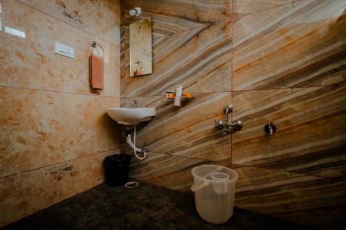 a bathroom with a sink and a toilet in a room at The Nature's Nest in Attigundi