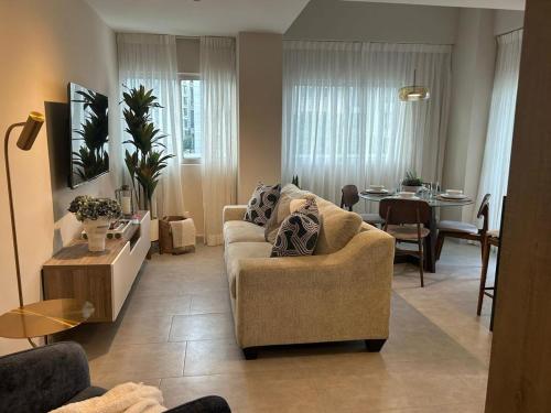 een woonkamer met een bank en een tafel bij REFA - 404 · Luxury 1BR Suite in Piantini | Modern • Pool • Gym in La Julia