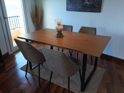 einem Esstisch mit Stühlen und einer Vase darauf in der Unterkunft Apartamento Teresa en Vilanova de Arousa in Pontevedra