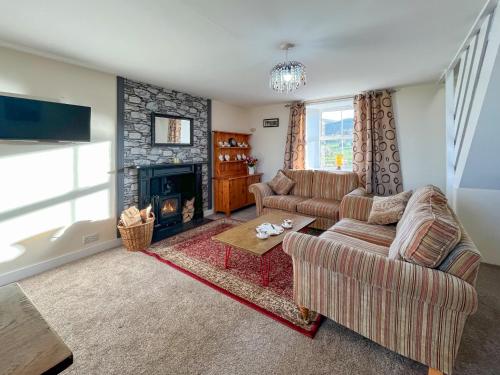 ein Wohnzimmer mit zwei Sofas und einem Kamin in der Unterkunft Ballygroggan Cottage - Uk48768 in Machrihanish