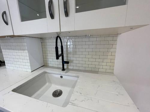 una cucina bianca con un lavello nel pavimento di The Hideaway Haven With Private Self Check-In a Belvedere