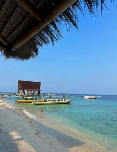 a beach with two boats in the water at Bronze Bungalow in Gili Meno