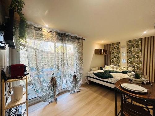 ein Schlafzimmer mit einem Bett und einem großen Fenster in der Unterkunft Casa Tropical in Les Ponts-de-Cé