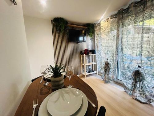ein Esszimmer mit einem Holztisch und einem Fenster in der Unterkunft Casa Tropical in Les Ponts-de-Cé