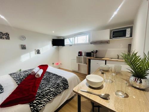 a living room with a bed and a wooden table at Casa Rubis in Les Ponts-de-Cé