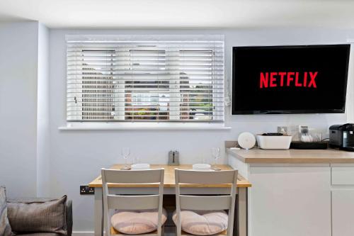 a kitchen with a table with two chairs and a television at The Patch with free parking By My Getaways in Brighton & Hove