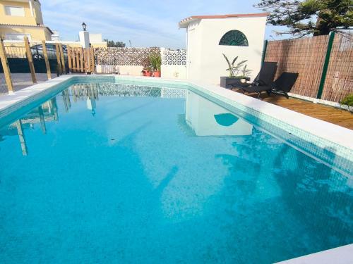 a large swimming pool with blue water at Casa Bonito in Vila Nova De Cacela