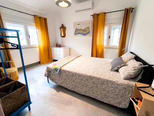a bedroom with a bed and two windows at Casa Bonito in Vila Nova De Cacela