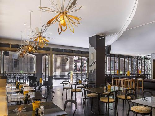 Un restaurante con mesas y sillas en una sala. en Mantra on Little Bourke Melbourne, en Melbourne
