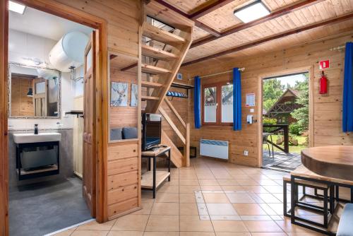 eine Küche mit einer Treppe in einem Holzhaus in der Unterkunft Domki letniskowe BAŁTYK in Łeba