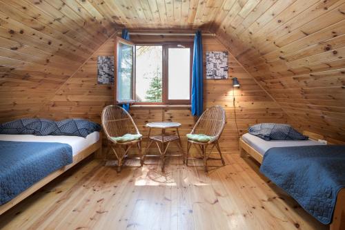 ein Zimmer mit zwei Betten und einem Tisch und Stühlen in der Unterkunft Domki letniskowe BAŁTYK in Łeba