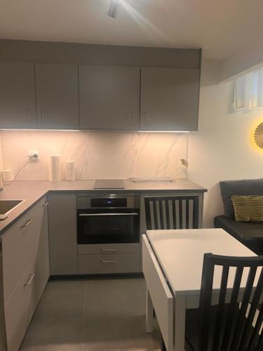 a kitchen with a stove and a table and a couch at Furnished apartment with parking in Malmö