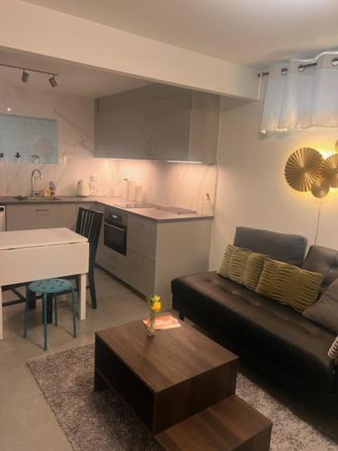 a living room with a couch and a table and a kitchen at Furnished apartment with parking in Malmö