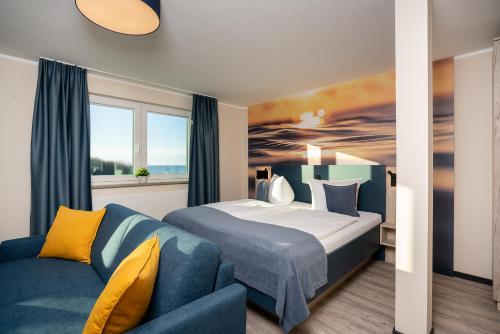 グラール・ミューリッツにあるHotel Ostseewogeのホテルルーム(ベッド1台、青いソファ付)