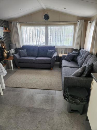 a living room with blue couches and a couch at Sam's Caravan Hire in Ingoldmells