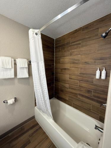a bathroom with a bath tub with a shower curtain at Days Inn by Wyndham Ocala North in Ocala