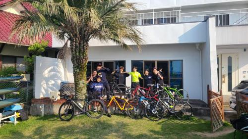 a group of people standing next to a group of bikes at Guest House Gamigami in Onomichi