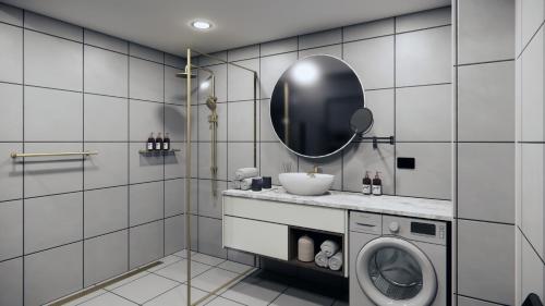 y baño con lavadora y espejo. en voco Darwin Suites by IHG, en Darwin