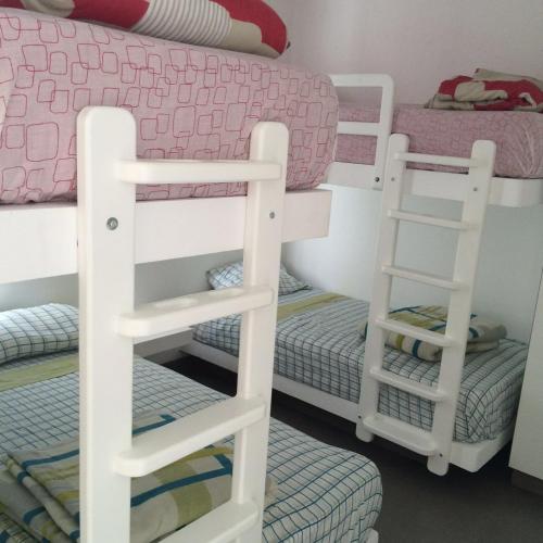 a bunk bed with two ladder bunk beds in a room at Dpto de playa en Paracas in Paracas