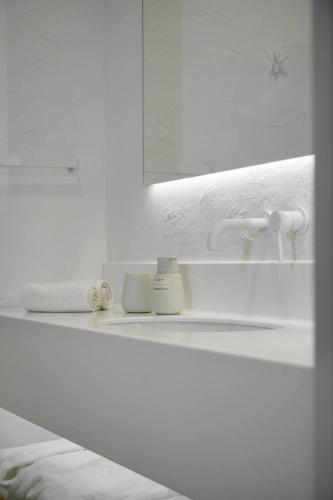a white bathroom with a sink and a mirror at Samatha space in Slavske