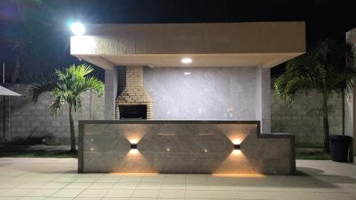 a stone bench in front of a building at night at aconchegante e tranquila in Parnamirim