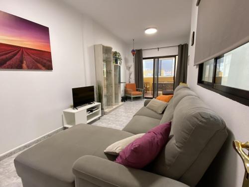 un soggiorno con un divano e una televisione di Al Magec Vacacional a Sardina