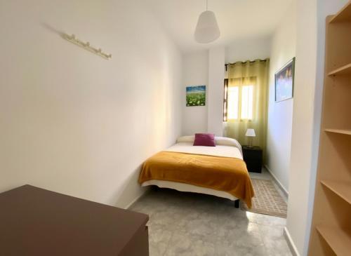 una camera da letto con un letto in una stanza bianca di Al Magec Vacacional a Sardina