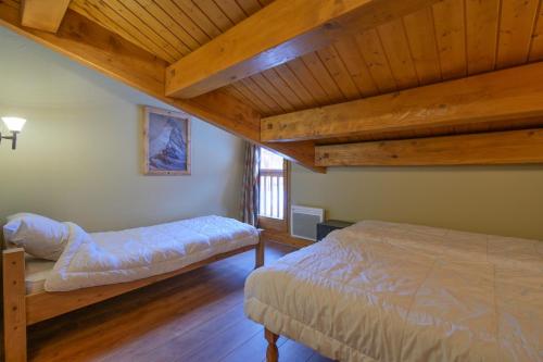 En eller flere senge i et værelse på lesetoilesdelaplagne Chalet 19