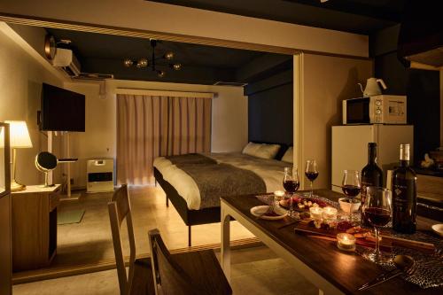 a room with a bed and a table with wine glasses at Make Your Hotel Susukino E in Sapporo