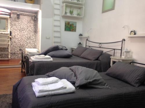 two beds in a living room with towels on them at Your Home in Town in Catania