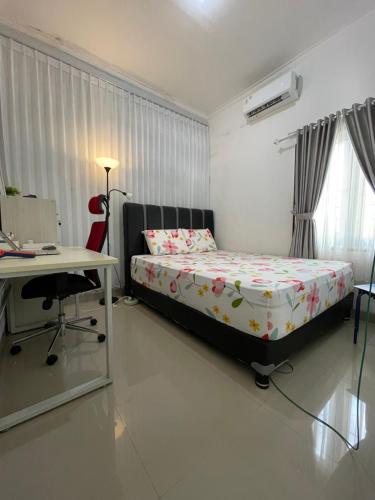 a bedroom with a bed and a desk and a deskablish at Casa de Brisa BnB in Prampuan