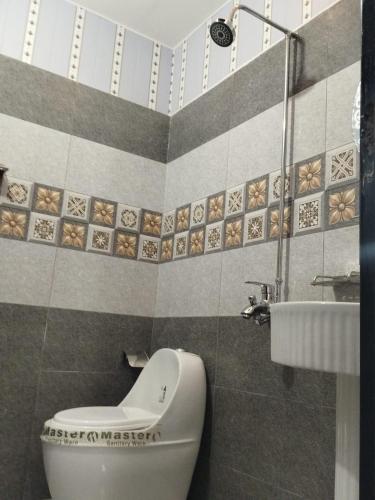 a bathroom with a toilet and a sink at Grand Orchard One Hotel in Lahore